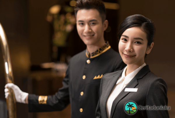 Petugas resepsionis hotel menjelaskan promo diskon tersembunyi kepada tamu di lobi elegan.