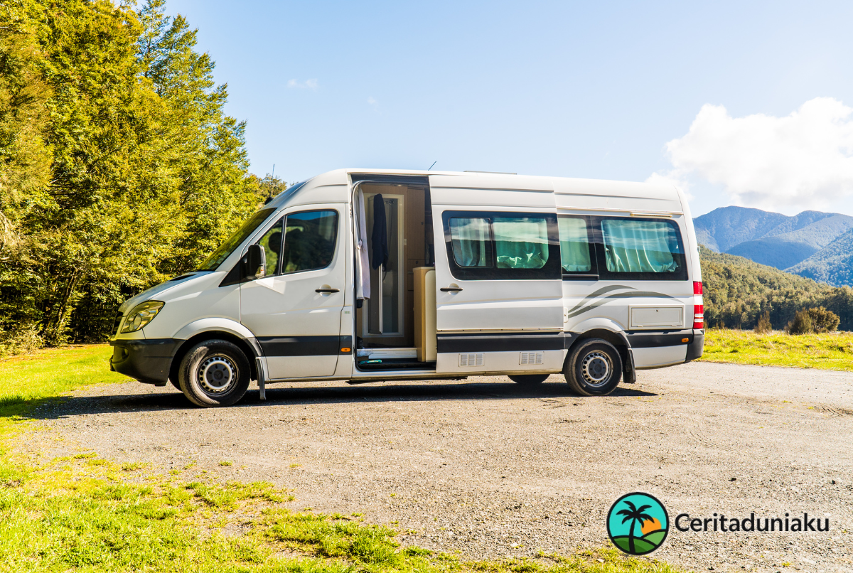 “Campervan modern terparkir di padang rumput hijau berlatar pegunungan, ilustrasi panduan perjalanan 2025.”